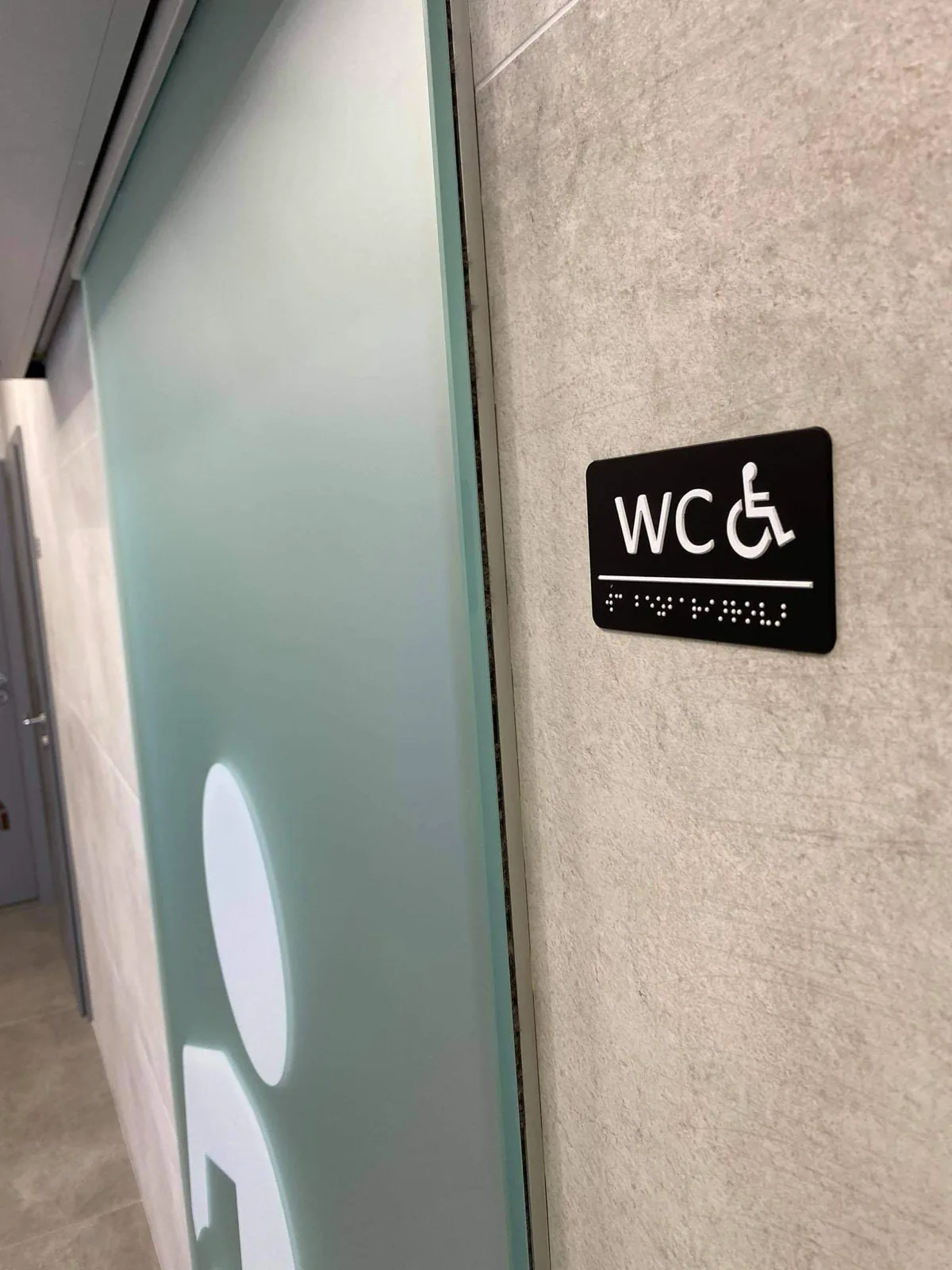 Štítok WC s Braillovým písmom na stene pri dverách